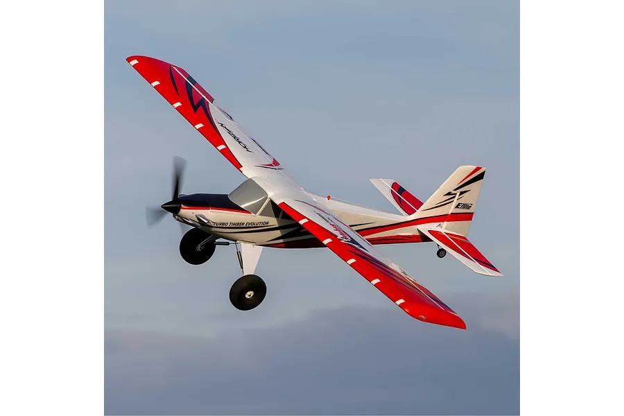 E-Flite Turbo Timber Evolution 1.5m RC plane in flight against a blue sky background.