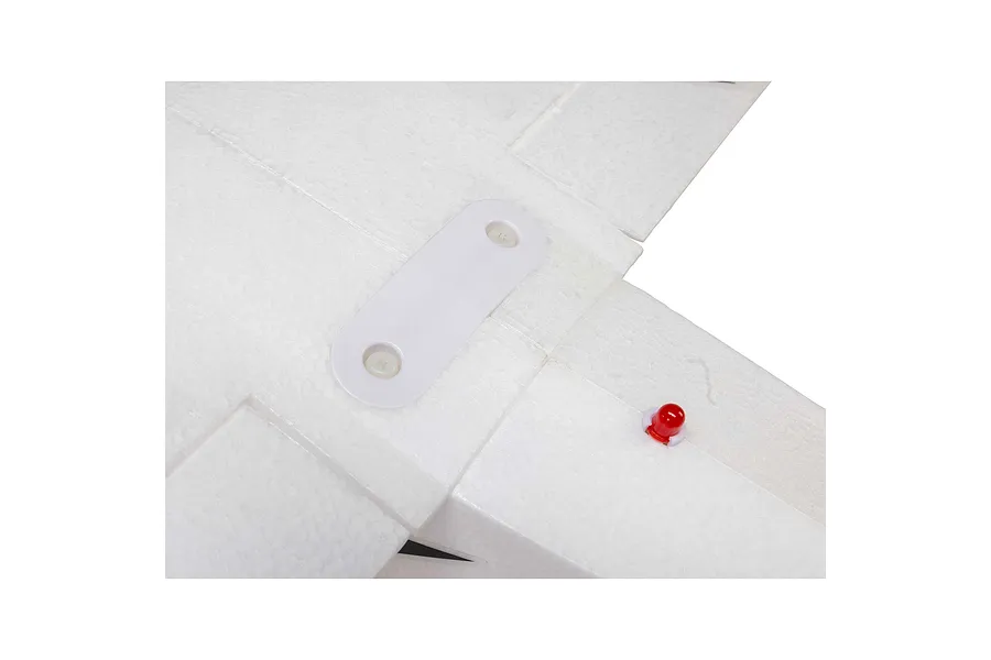 Top-down studio view of white foam RC aircraft tail assembly with a red LED beacon and mounting plate.