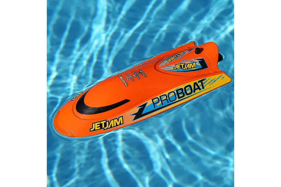 Pro Boat Jet Jam V2 orange RC speed boat floating in a blue swimming pool water.