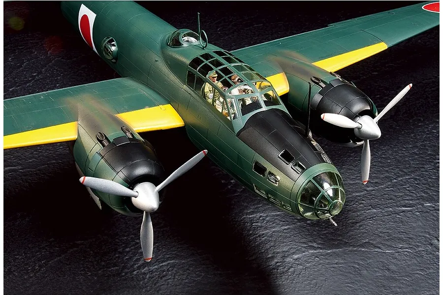 A high-angle close-up of a Tamiya 1/48 scale Mitsubishi G4M1 Model 11 plastic model aircraft, showing the cockpit, engines, and green fuselage.