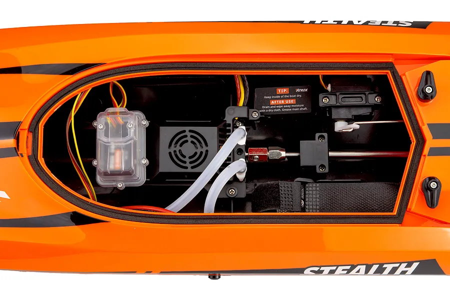 Top-down view of the open hull interior of the orange Atrek Stealth RC boat, showing internal electronics and water-cooling tubes.