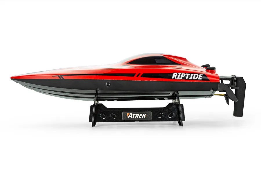 Side profile of the Atrek Riptide red and black RC speed boat resting on a matching stand against a white background.