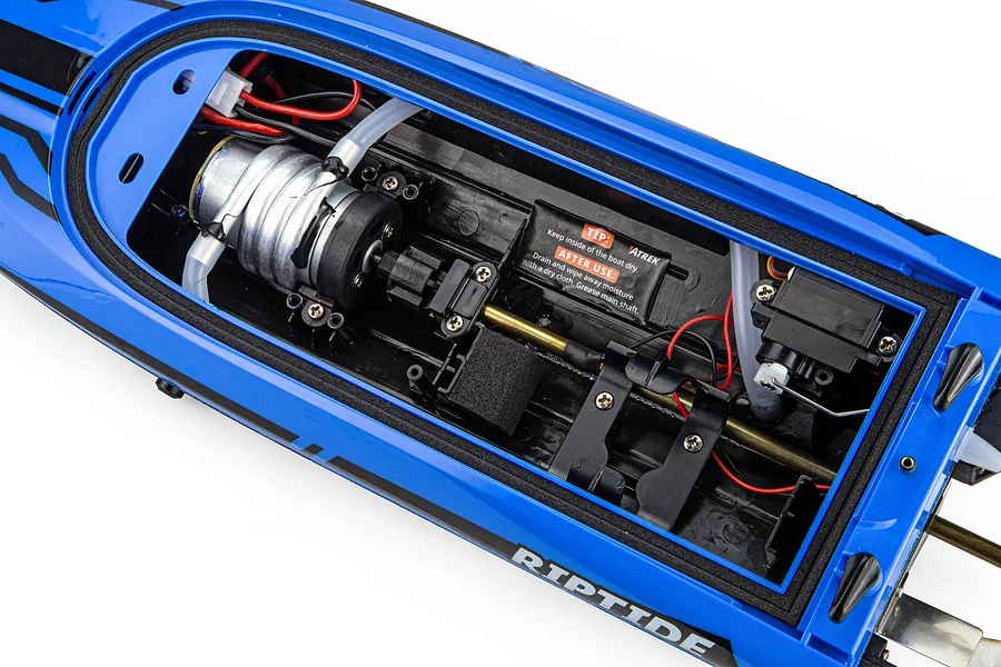 Top-down view of the internal components inside the blue hull of the Atrek Riptide RC boat, showing motor, wiring, and servo.