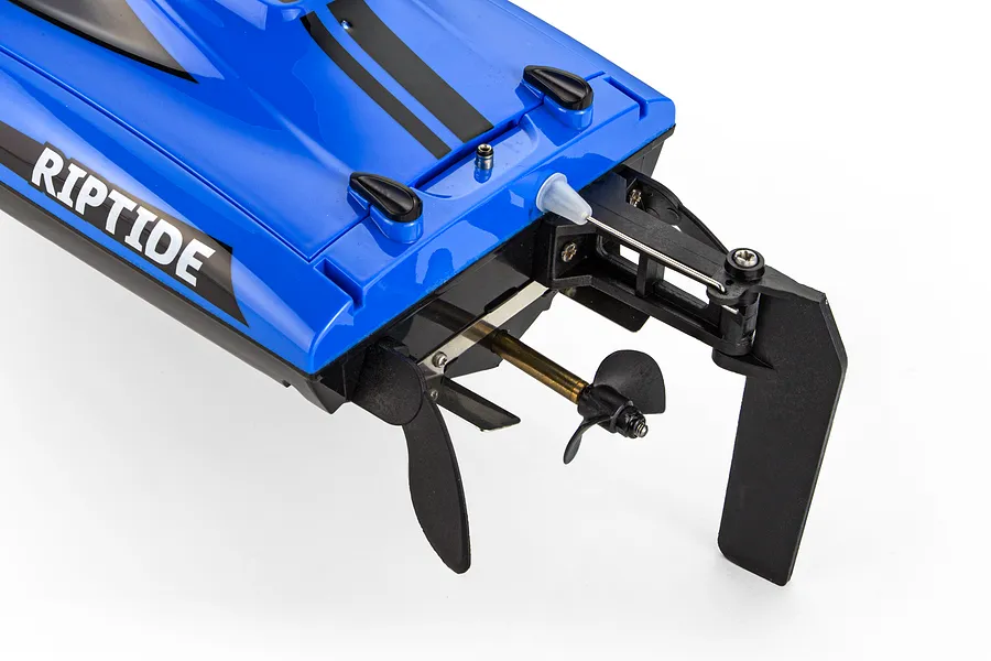 Rear transom detail of the blue Atrek Riptide RC speed boat showing the rudder, propeller, and drive shaft hardware.