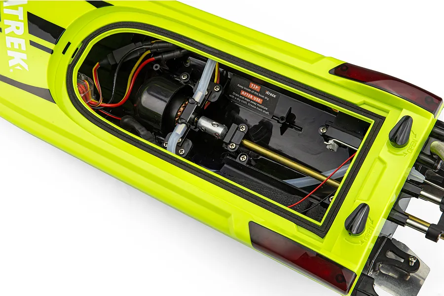 Top-down view of the open interior hull of the Atrek Rogue 22 inch green brushless RC speed boat showing the motor, wiring, and drive shaft.