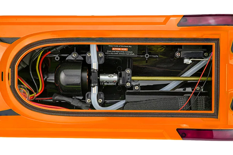 Top down view of the interior hull of the orange Atrek Rogue 22 inch brushless RC speed boat showing motor, cooling lines, and drive shaft.