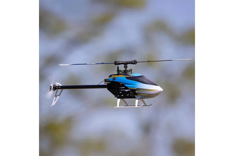 Blade Revolution 155 CP RC helicopter in flight against a blurred outdoor background, showing blue, black, and white canopy.