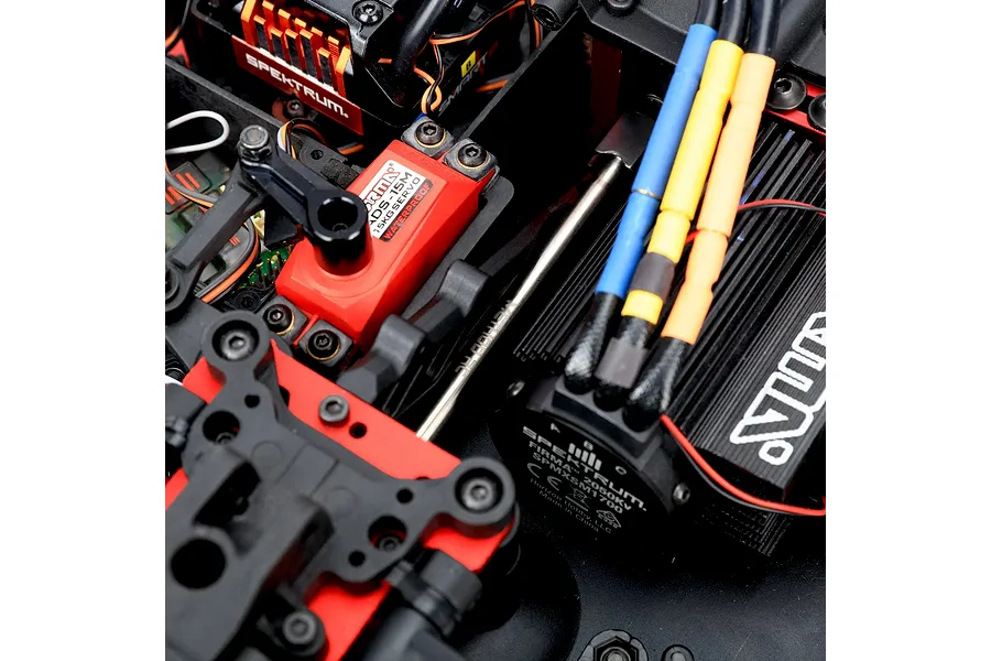 Close-up of an installed Method RC titanium centre front driveshaft in an RC vehicle chassis near electronic components.