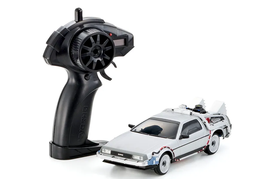 Kyosho First Mini-Z Back to the Future DeLorean RC car with its black pistol grip transmitter against a white background.