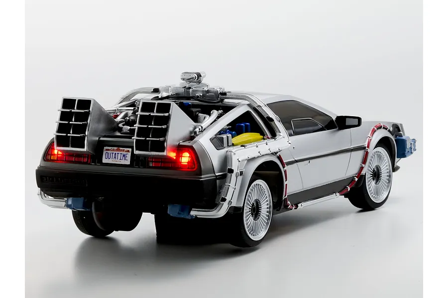 Rear three-quarter studio view of the Kyosho First Mini-Z Back to the Future DeLorean RC car showing lit tail lights and time machine details.
