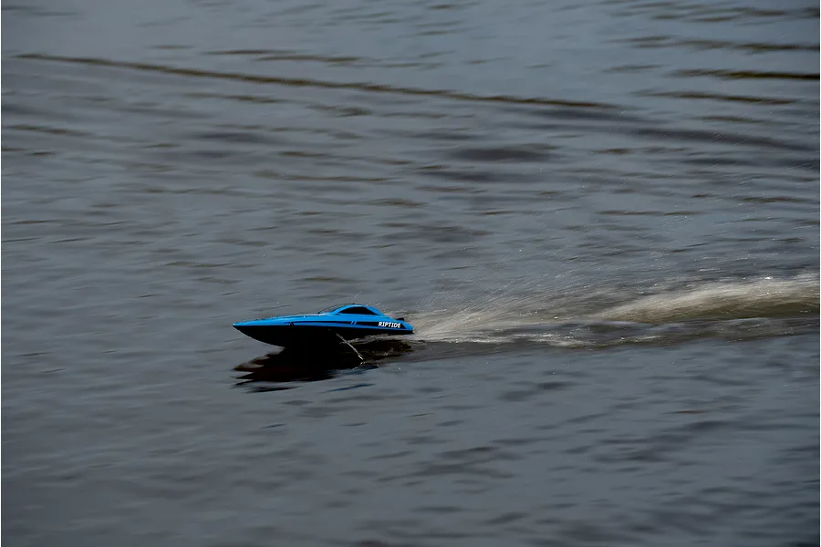 Atrek Riptide blue RC speed boat running across open water, creating a white spray wake.