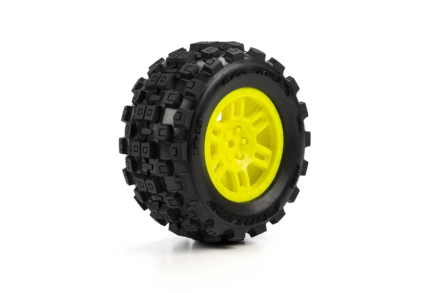 Studio photo of a Pro-Line 1/16 Badlands MX MT tyre mounted on a bright yellow split-six rim against a white background.