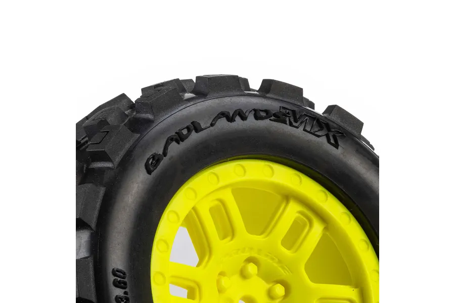 Close-up of a Pro-Line Badlands MX tyre on a yellow split-six RC wheel against a white background.