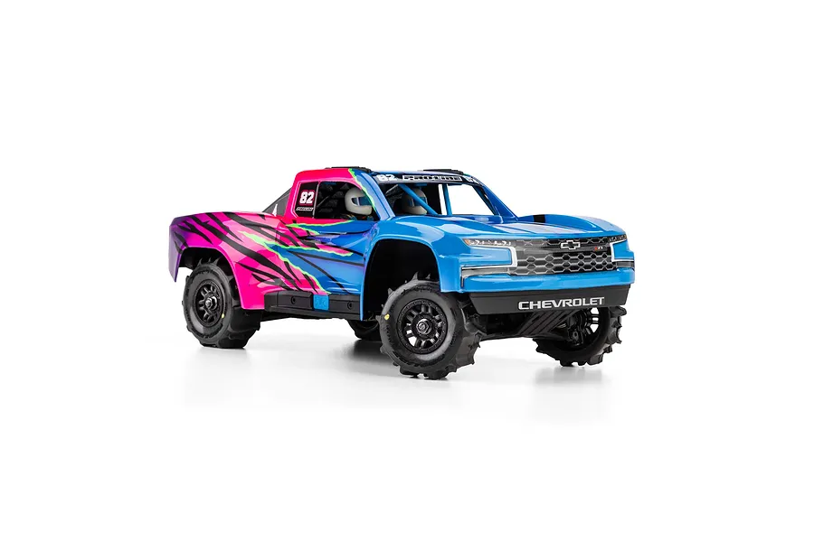 An RC short course truck with blue and pink Chevrolet body mounted on black wheels with paddle tyres.