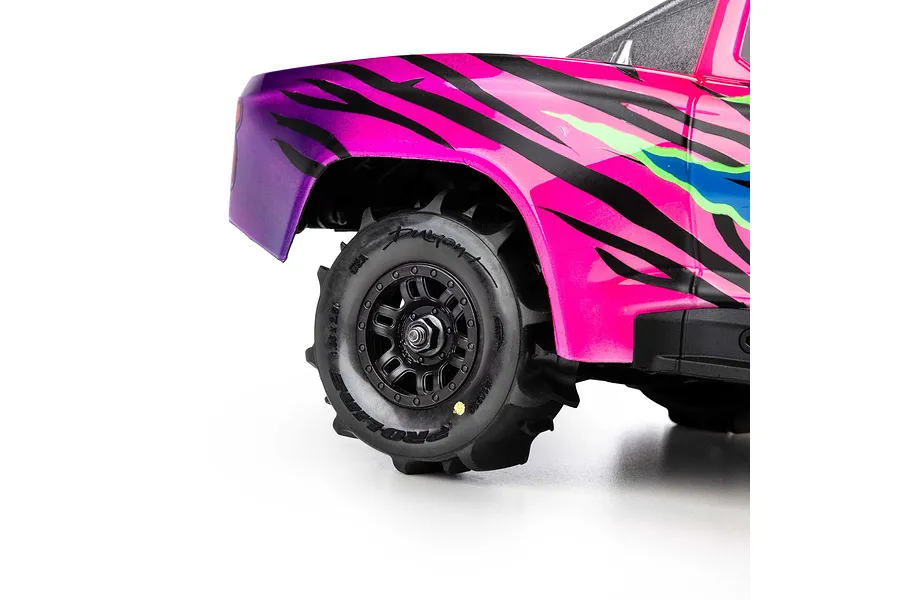 Close-up of a Pro-Line Dumont paddle tyre mounted on a black split-six rim fitted to an RC truck against a white background.