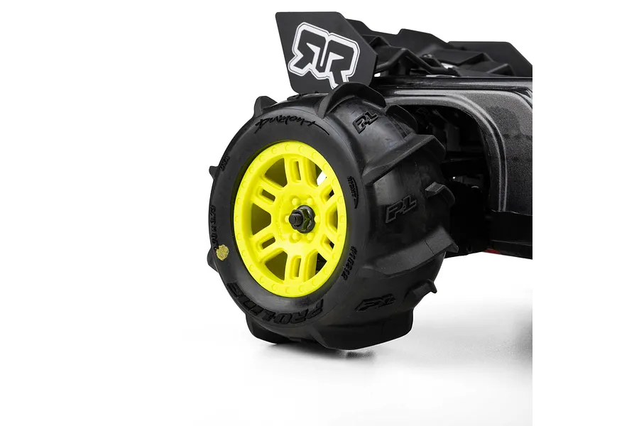 Pro-Line Dumont paddle tyre mounted on a yellow split-six wheel installed on an RC car against a white background.