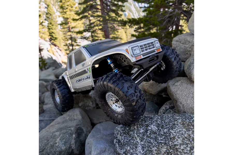 Pro-Line 1.9 inch Chisel II crawler tyres fitted to an RC rock crawler traversing an outdoor rocky terrain.