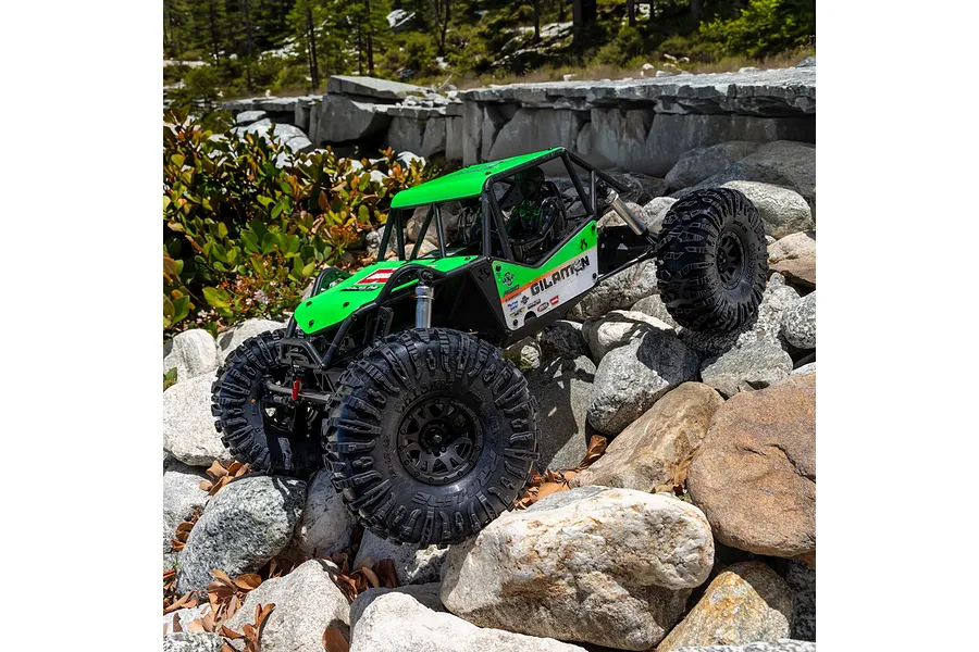 Green RC rock crawler with Chisel II tyres tackling a rocky outdoor trail during daytime.