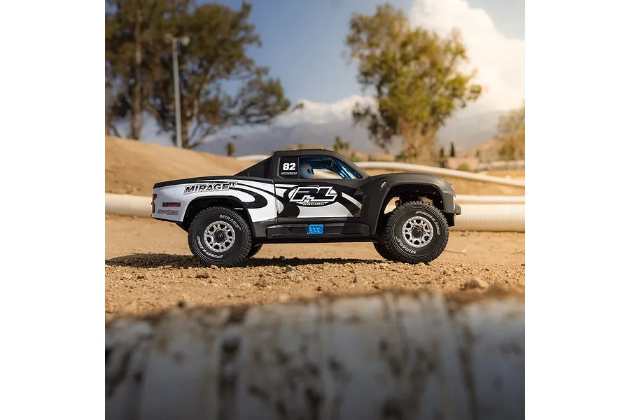 Pro-Line matte black trophy truck body shell mounted on an RC chassis on a dirt track outdoors.