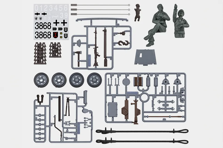 Top-down studio view of Heng Long 1/16 German Stug III tank accessory pack including plastic parts trees, figures, decals, and tow cables.