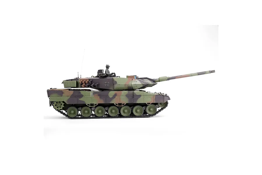 Side view profile of the Taigen German Leopard 2A6 RTR RC tank featuring a camouflage paint scheme and commander figure against a white background.