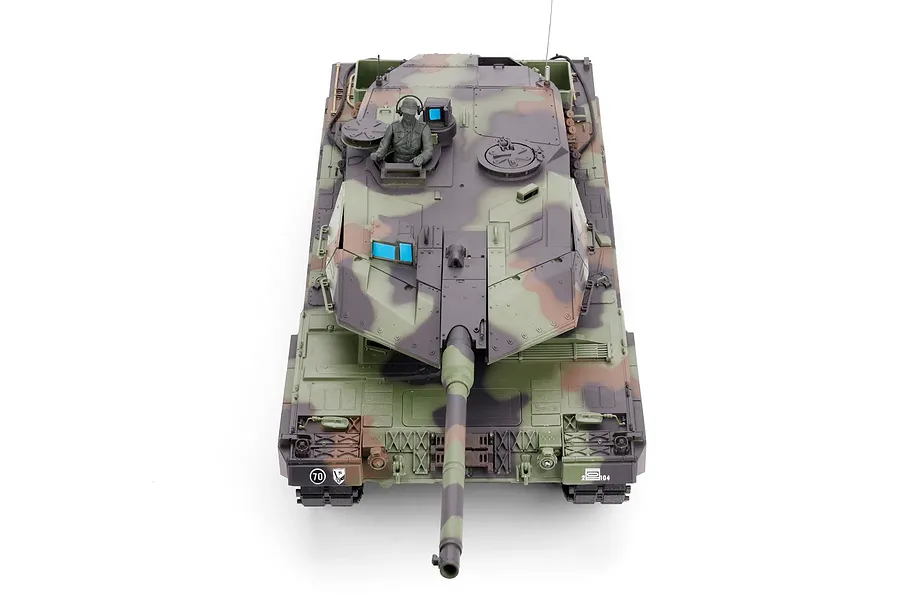 Top-down view of the Taigen German Leopard 2A6 RC tank, featuring a camouflage finish, gun turret, and commander figure against a white background.