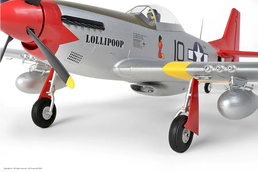 Close-up of the Arrows RC P-51 Mustang 850mm warbird showing fuselage details, markings, propeller, landing gear, and drop tanks against a white background.