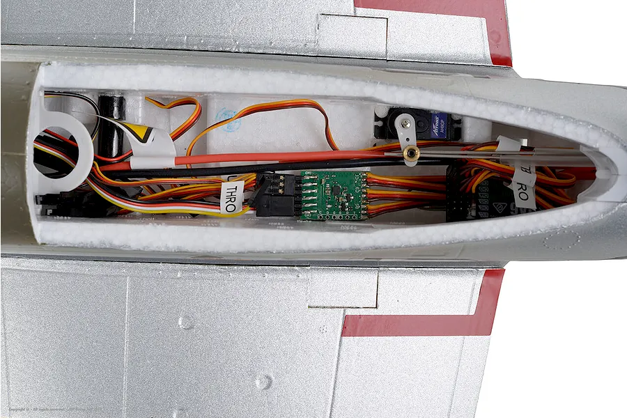 Top-down view of the interior electronics compartment of the Arrows RC P-51 Mustang showing receiver, wiring, servo, and control linkages.
