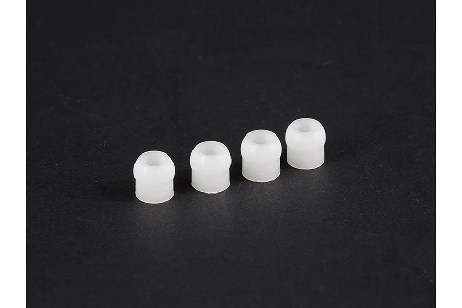 Four small white plastic pivot balls arranged in a row against a dark background.