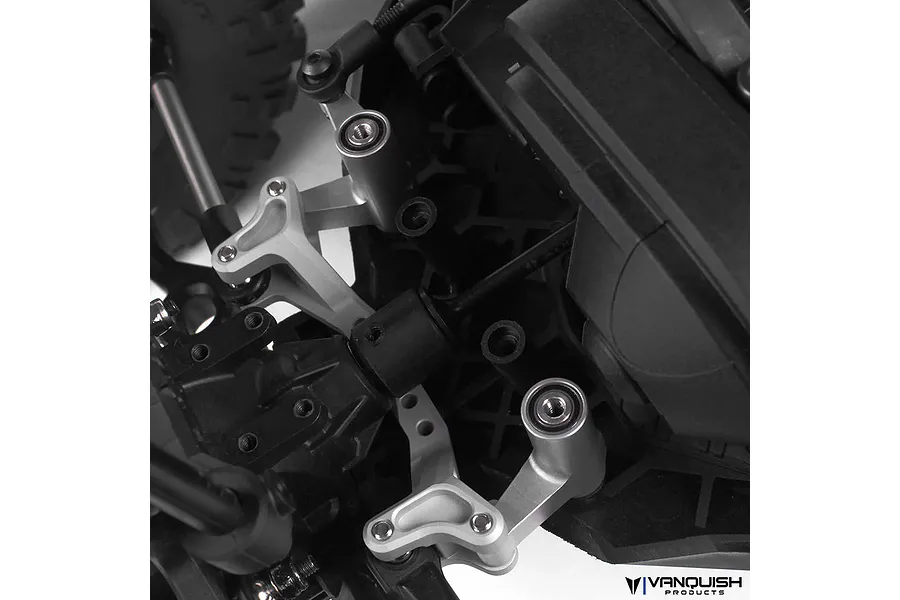 Close-up of silver aluminium steering rack components installed on an RC vehicle chassis.