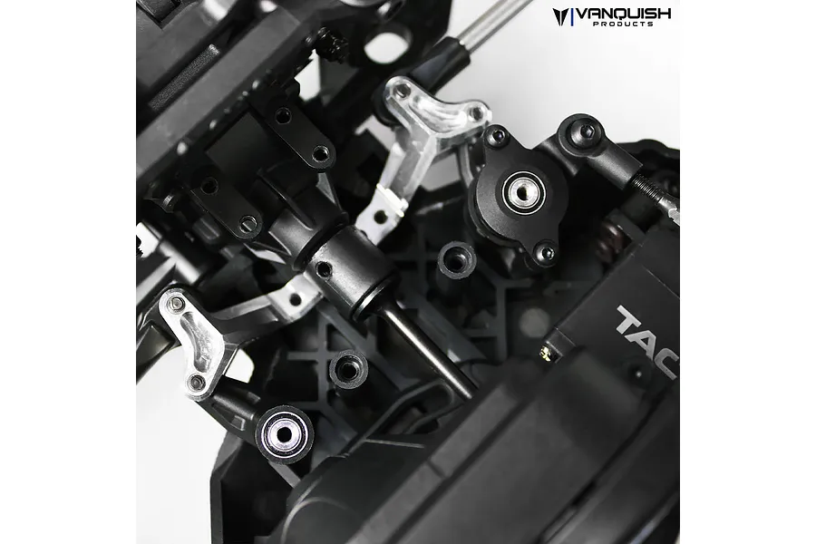 Close-up of a Vanquish silver aluminium steering rack installed on an RC vehicle chassis.