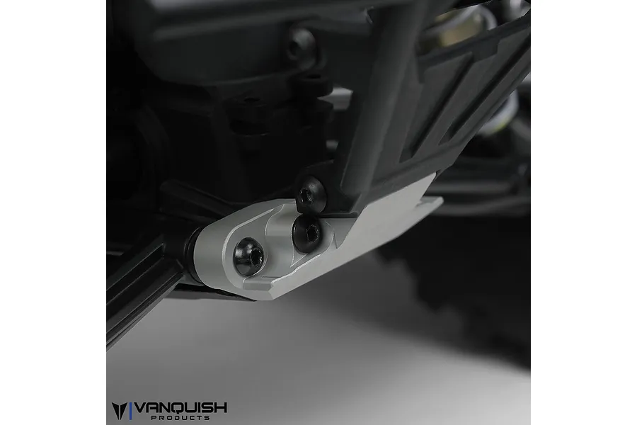 Close-up of a silver aluminium front skid plate installed on an RC vehicle chassis, featuring black screws and a Vanquish Products logo in the corner.
