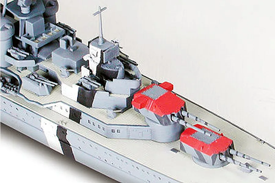 A close-up view of a 1/700 scale model of the German heavy cruiser Prinz Eugen, showing the forward deck, gun turrets, and superstructure.