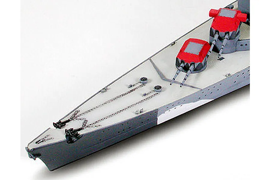 Close-up of the bow section of a 1/700 scale Tamiya Prinz Eugen model ship, showing deck details, anchor chains, and red-topped gun turrets.