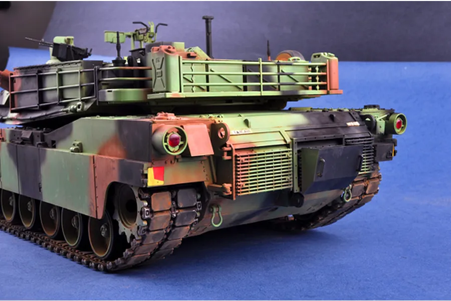 Rear view of a 1/16 scale Trumpeter M1A1 Abrams tank model kit featuring camouflage paint and detailed rear engine deck.