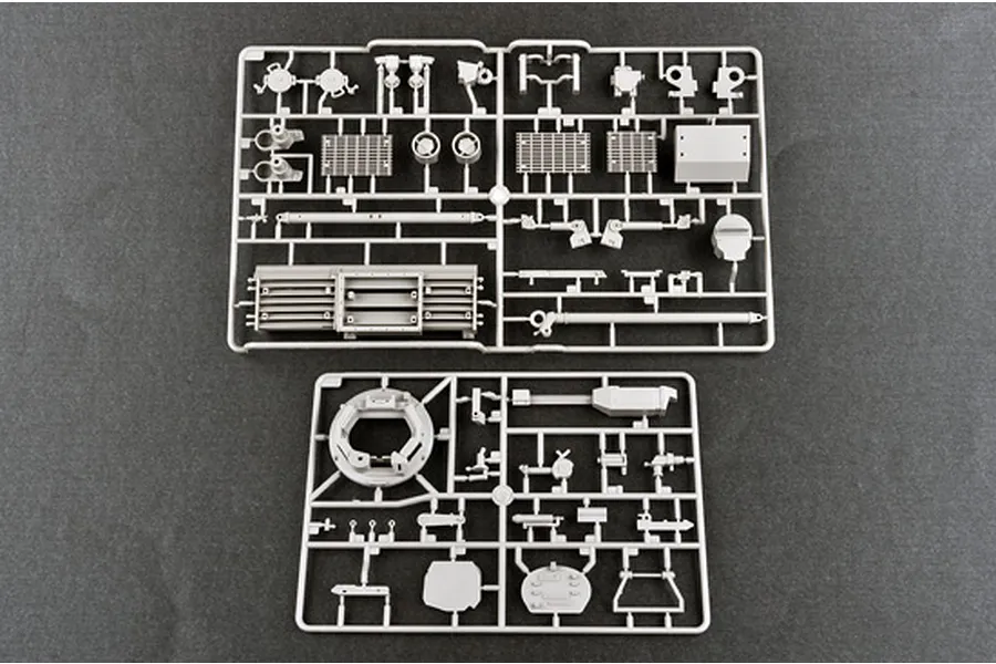 Two grey plastic model kit sprues containing various tank parts, laid out on a dark grey surface.