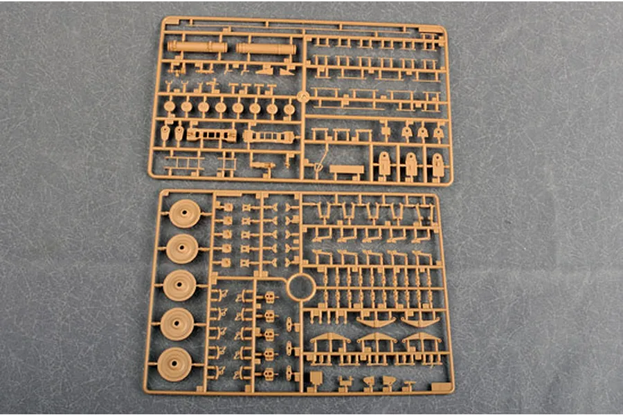 Two tan plastic model kit sprues containing various small parts, wheels, and structural components for a 1/35 scale military vehicle model.