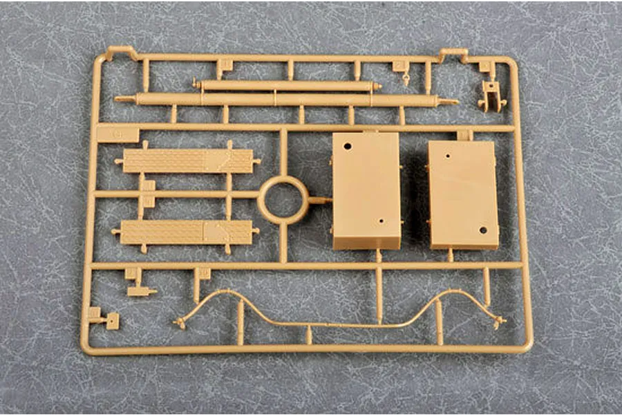 A tan plastic model kit sprue containing various parts for a German Morser Karl self-propelled gun model, set against a grey textured background.