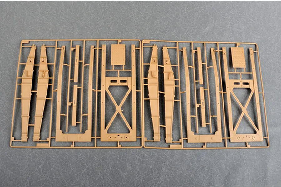 Two identical tan plastic model kit sprues showing structural frame components for a large military vehicle.