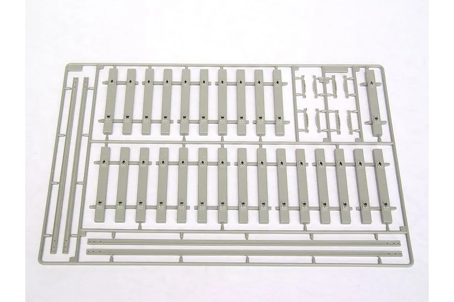 A grey plastic sprue from a model kit containing railway track sections and small components.
