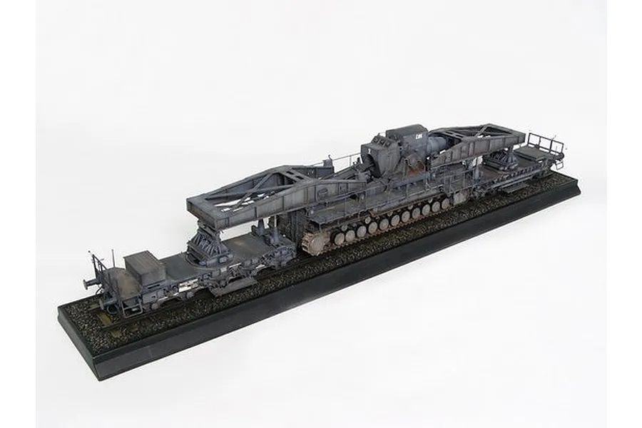 A 1/35 scale plastic model of the German Morser Karl self-propelled siege mortar on a railway transport carrier, displayed on a black base.