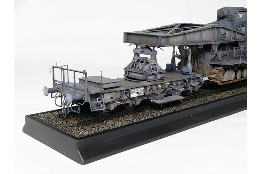 A detailed scale model of a German Morser Karl railway transport carrier on a display base.