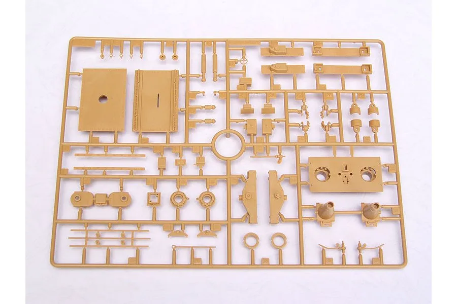 A tan plastic model kit sprue containing various unpainted parts for a military vehicle model, viewed from directly above.