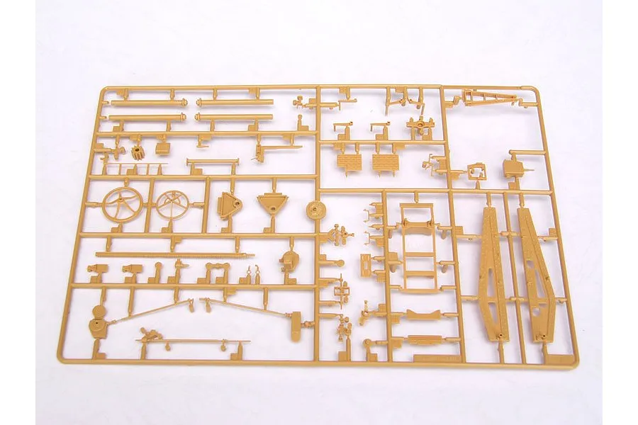 A tan plastic model kit sprue containing various small parts for a military vehicle model, laid out on a white background.