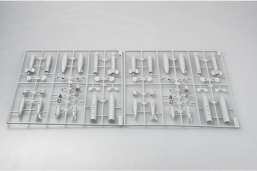 Two identical grey plastic model kit sprues containing various missile and fuel tank components for a fighter jet model.