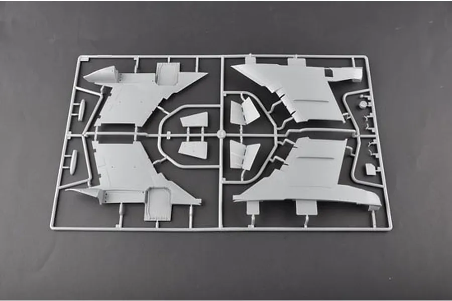 A grey plastic sprue containing various aircraft model parts, including wing sections, laid out on a dark grey background.