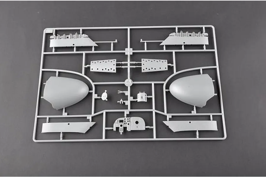A grey plastic sprue from a model aircraft kit featuring various fuselage and cockpit parts.