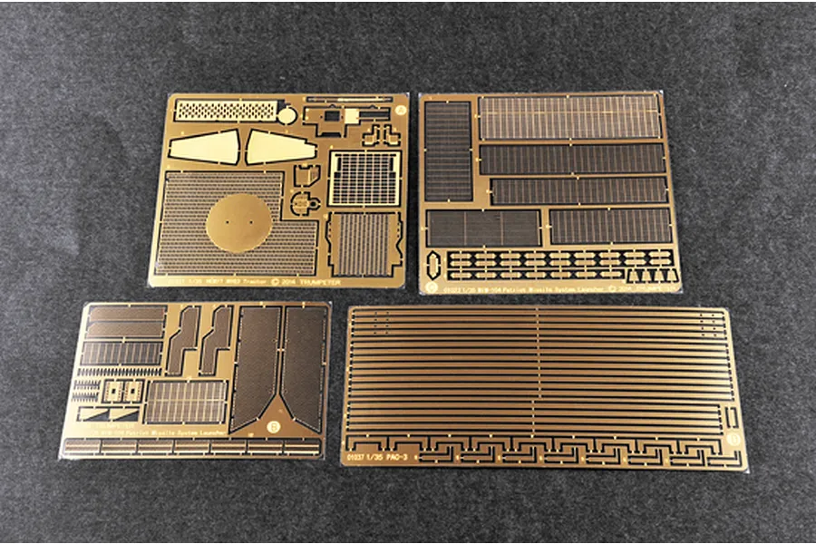 Four photo-etched brass detail sheets for a 1/35 scale Trumpeter Patriot missile system model kit, laid out on a dark grey surface.