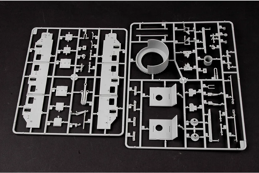 Two grey plastic model kit sprues containing various parts for a German Panzerlok locomotive model, laid out on a black surface.