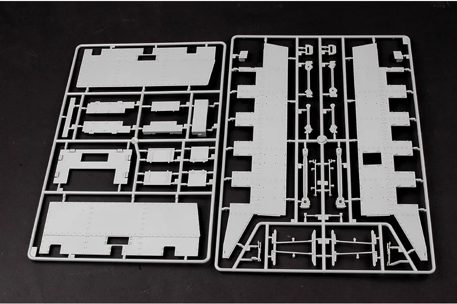 Two grey plastic model kit sprues containing various flat armoured panels and structural components for a 1/35 scale military locomotive model.